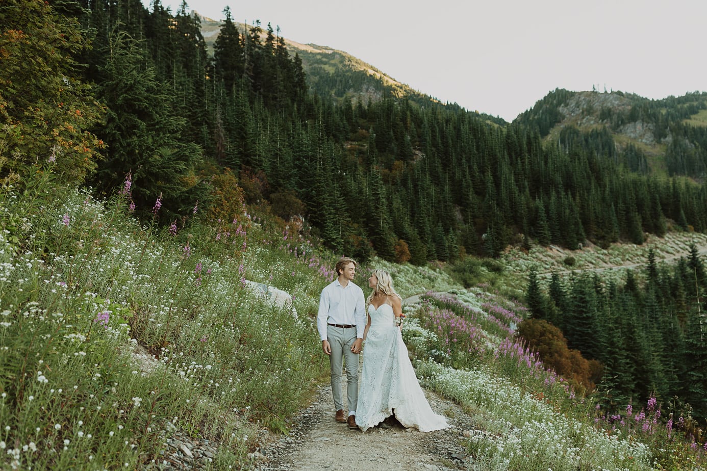 couple walking through a wildflower meadow during their hiking elopement in chilliwack
