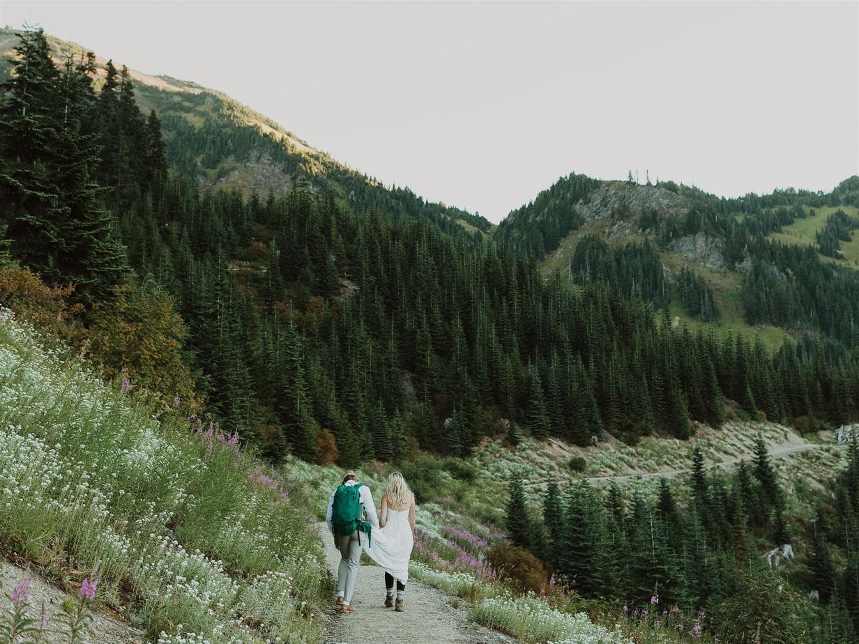 couple hiking through wildflower meadow on their elopement day
