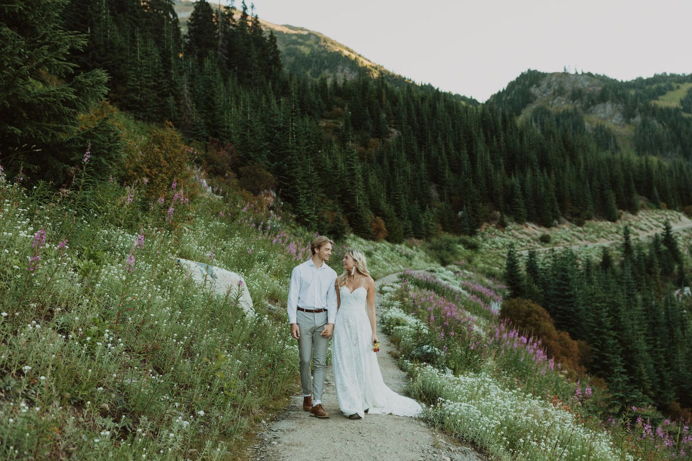 Couple waking through a wildflower meadow on their elopement in Chilliwack, BC.