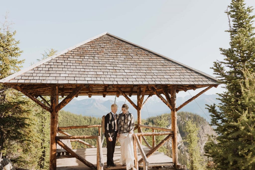 Couple walking through a hut on a mountaintop during their elopement