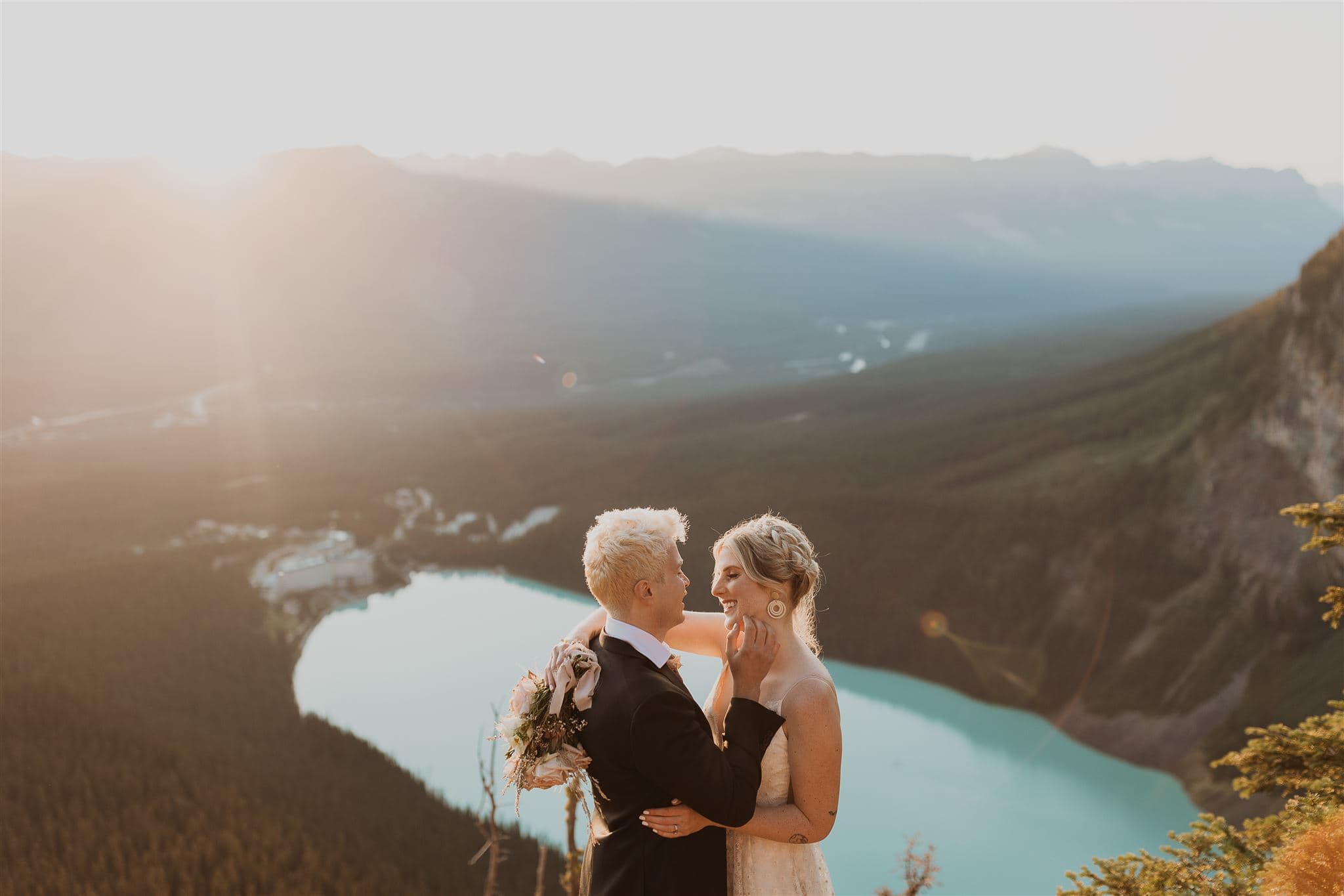 Couple hiking to peak of Lake Louise on their elopement during sunrise.