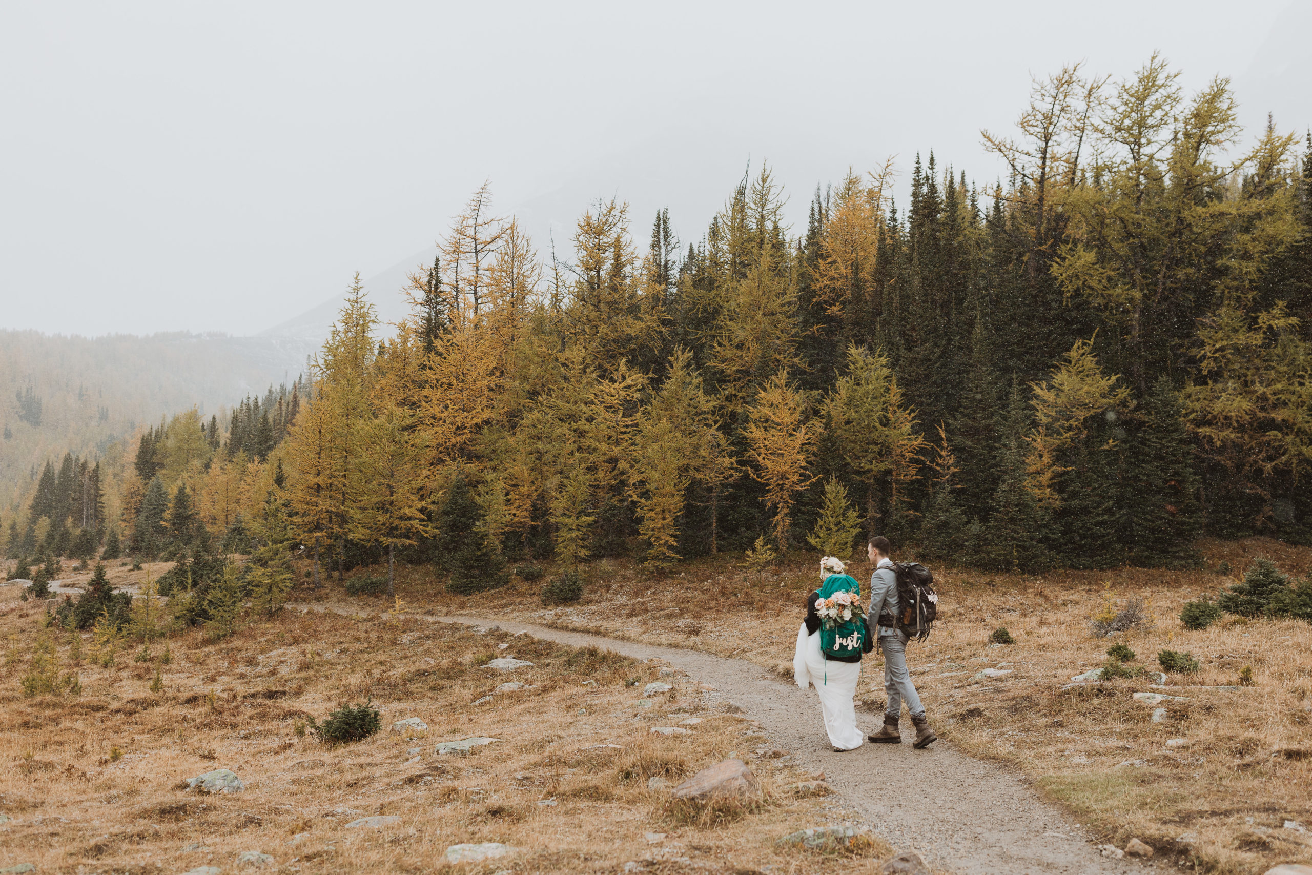 couple hiking through the larches at moraine lake on their elopement day