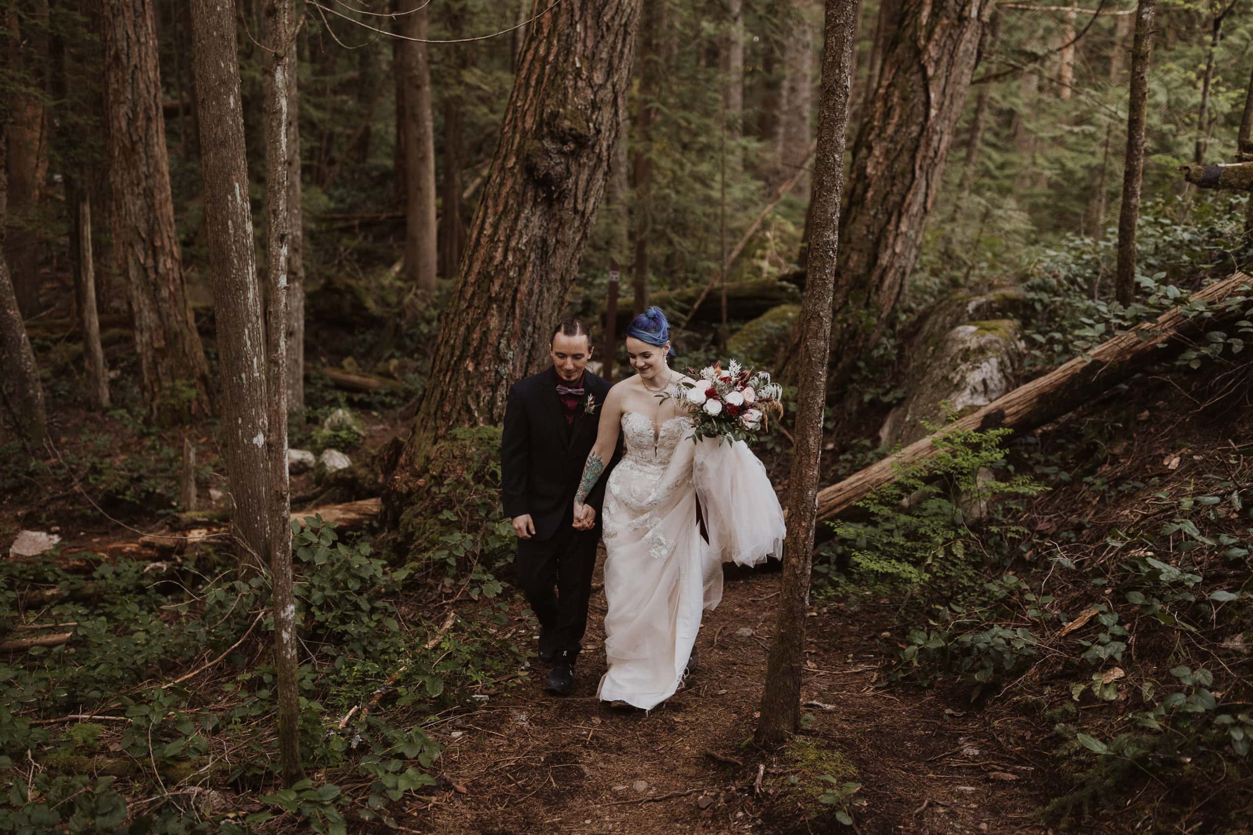 couple hiking through a trail during their hiking bc elopement in squamish
