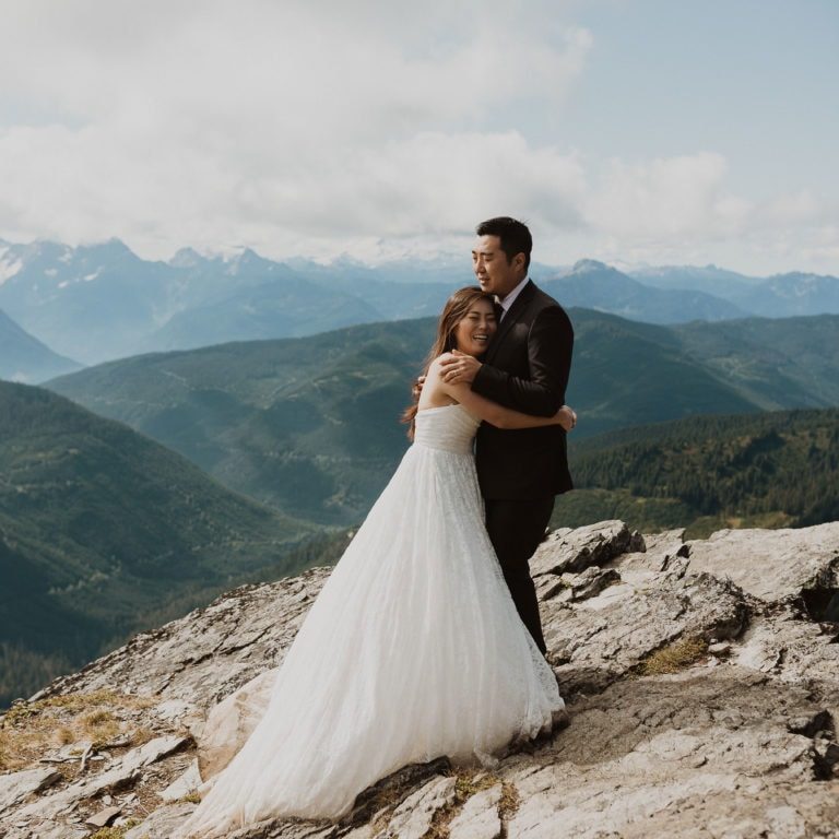 Couple standing on mountaintop for their BC elopement.